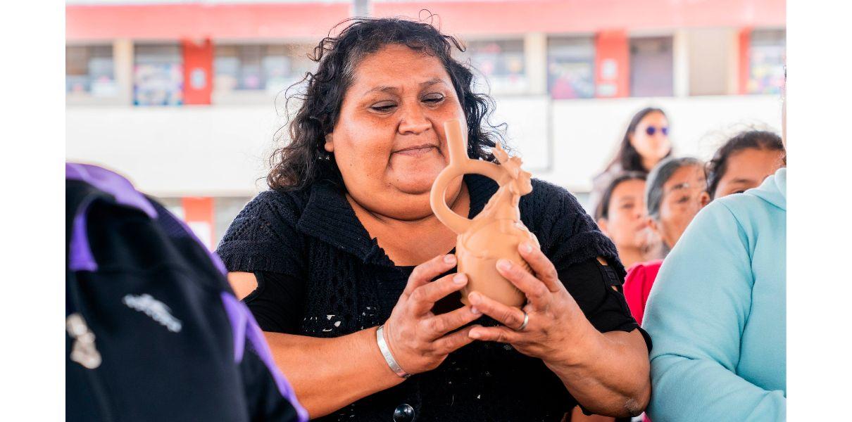 Figura 6. Vecina de Magdalena de Cao explorando una r&eacute;plica 3D de cer&aacute;mica Mochica durante los talleres de difusi&oacute;n cultural del complejo arqueol&oacute;gico El Brujo. 